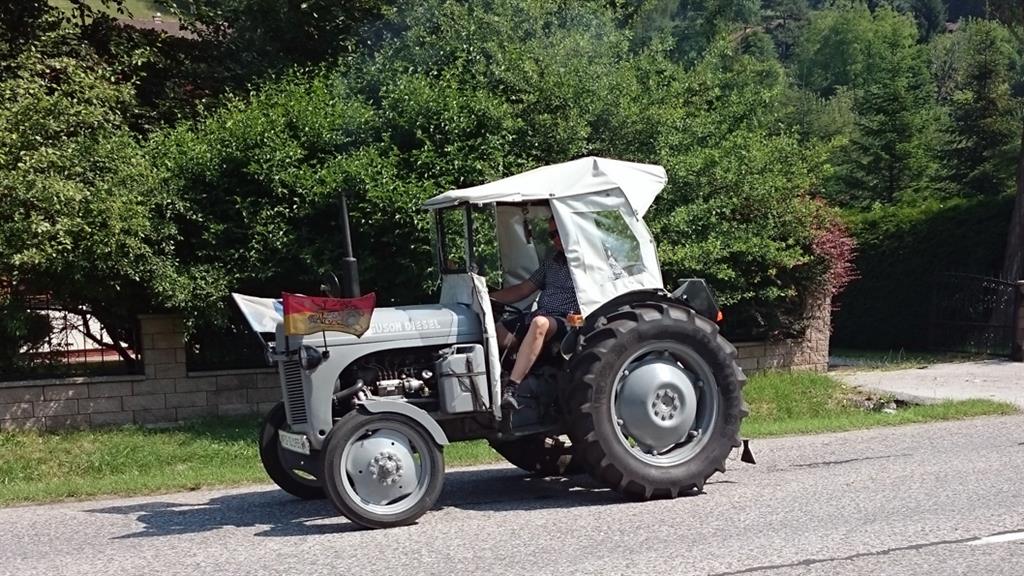 La sosta per la riparazione della catena attira l'attenzione dei partecipanti ad un raduno di trattori storici.jpg